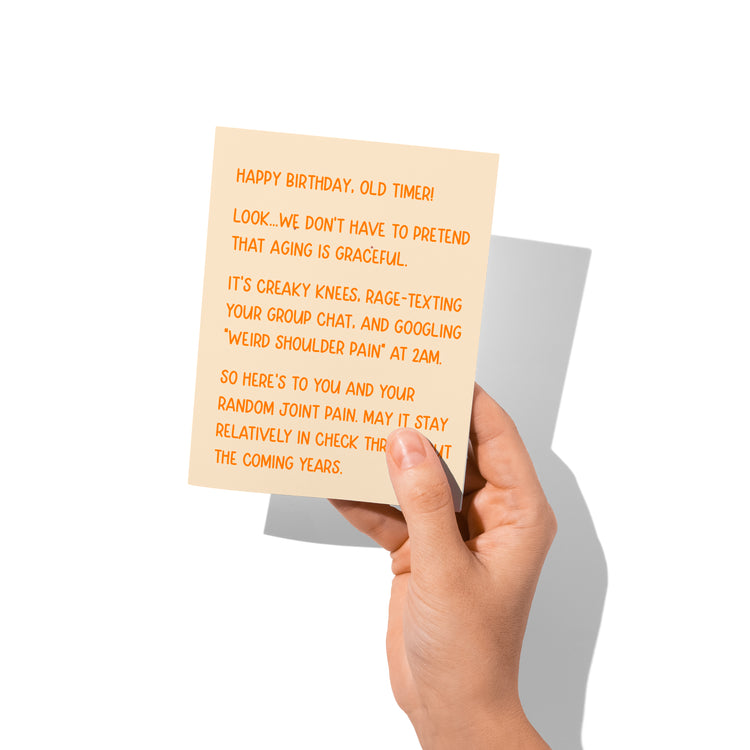 Funny birthday card held in hand, sarcastic aging humor design.