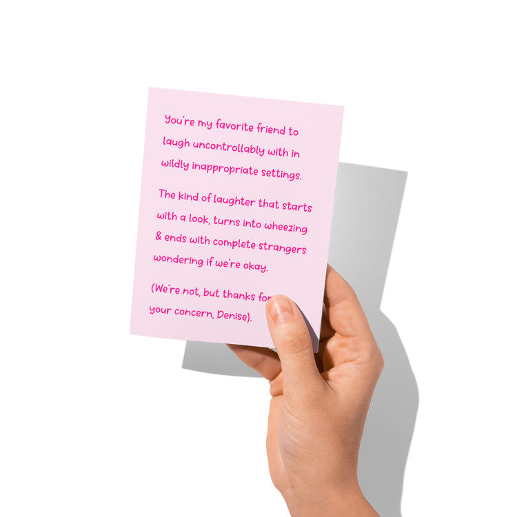 Funny friendship card held in hand, humorous wheeze-laugh message visible.