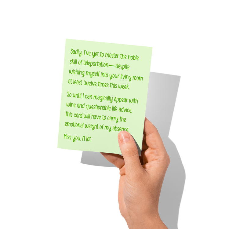 Funny friendship card held in hand, humorous miss-you message visible.
