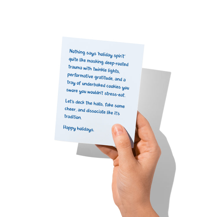 Funny holiday card held in hand, humorous Christmas chaos message visible.
