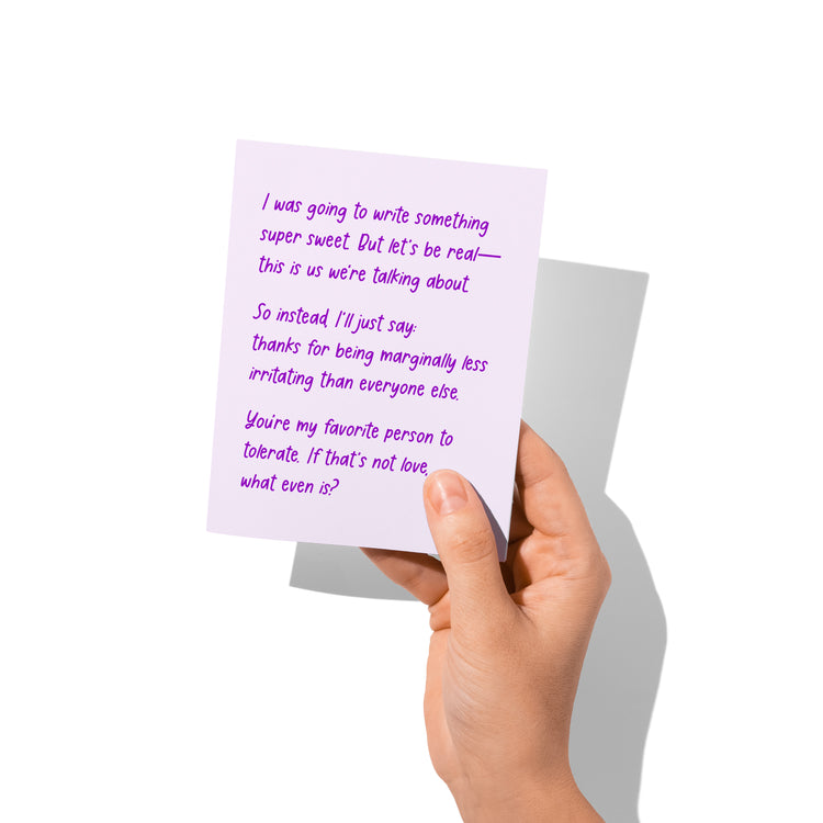 Funny love card held in hand, humorous love message visible.