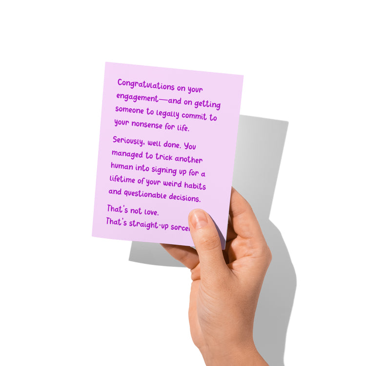 Hand holding a purple card with humorous text on a white background