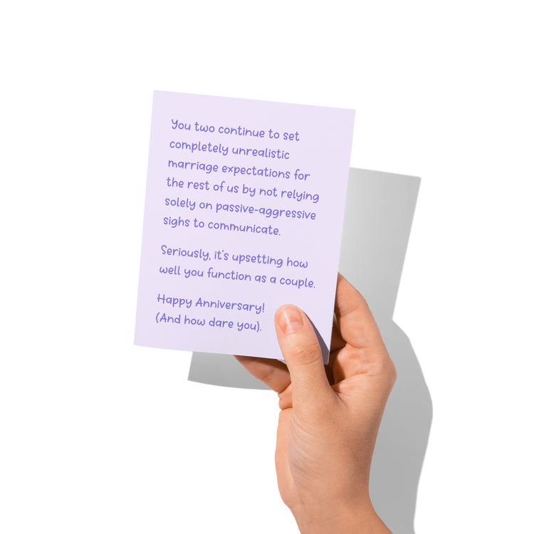 Funny anniversary card held in hand, humorous anniversary message visible.