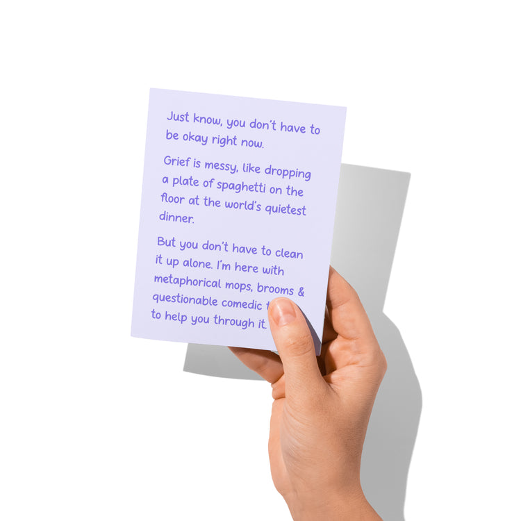 sympathy card held in hand, humorous grief comfort message visible.