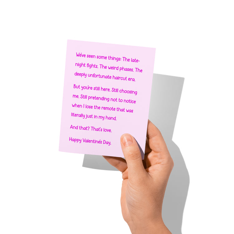 Funny Valentine’s card held in hand, humorous love message visible.