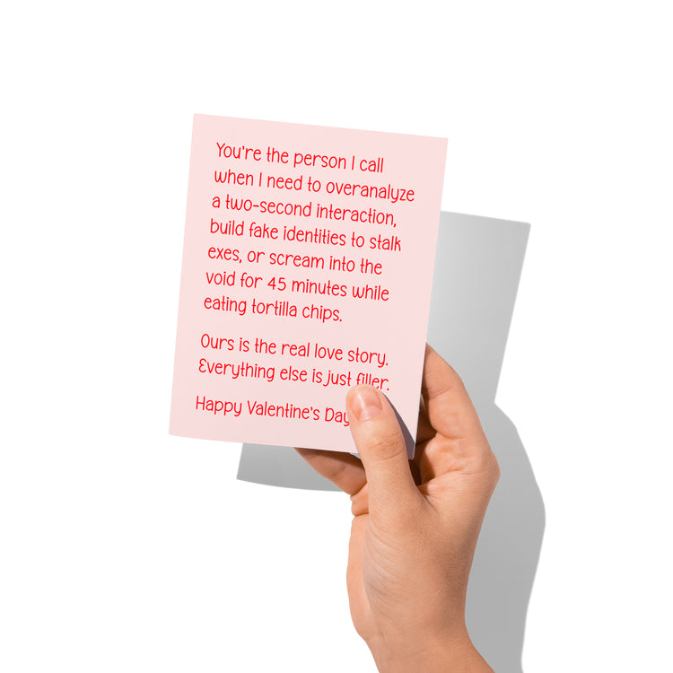 Funny Valentine’s card held in hand, humorous chaotic relationship message visible.