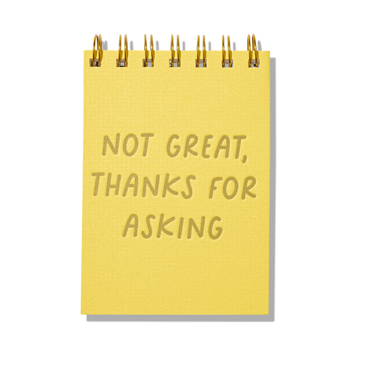Yellow letterpress mini jotter with gold text “Not Great, Thanks for Asking” and spiral binding.