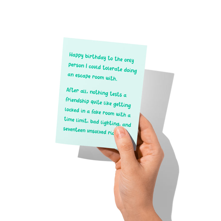 Funny birthday card held in hand, humorous friendship message.