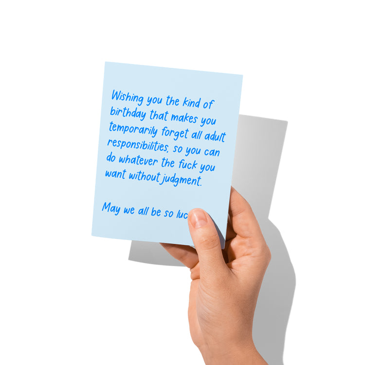 Funny birthday card held in hand, humorous adulting message.
