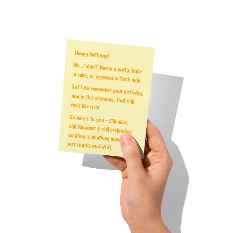 Funny birthday card held in hand, humorous snarky message.