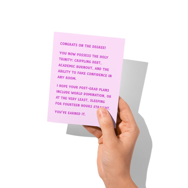 Funny graduation card held in hand, humorous grad chaos message visible.