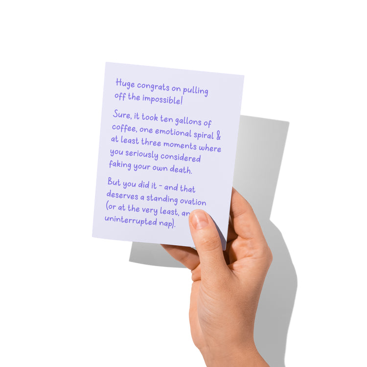 Funny congrats card held in hand, humorous achievement humor visible.