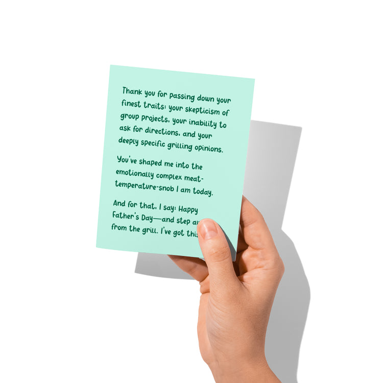 Funny Father’s Day card held in hand, humorous grilling joke visible.