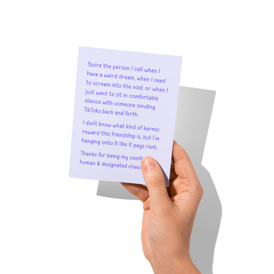 Funny friendship card held in hand, humorous comfort human message visible.