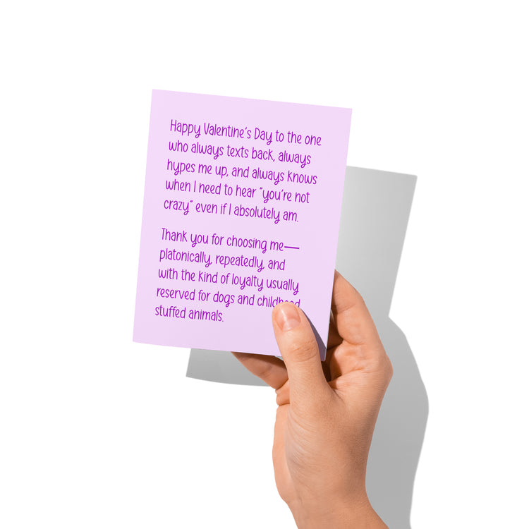 Funny platonic Valentine’s card held in hand, humorous best friend message visible.