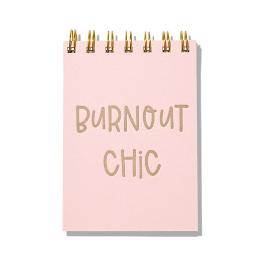 Pink letterpress mini jotter with gold text “Burnout Chic” and gold spiral binding.
