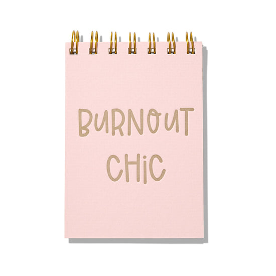 Pink letterpress mini jotter with gold text “Burnout Chic” and gold spiral binding.
