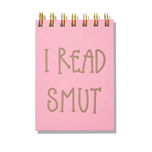 Pink mini jotter with letterpress text “I Read Smut” and gold spiral binding.