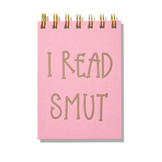 Pink mini jotter with letterpress text “I Read Smut” and gold spiral binding.
