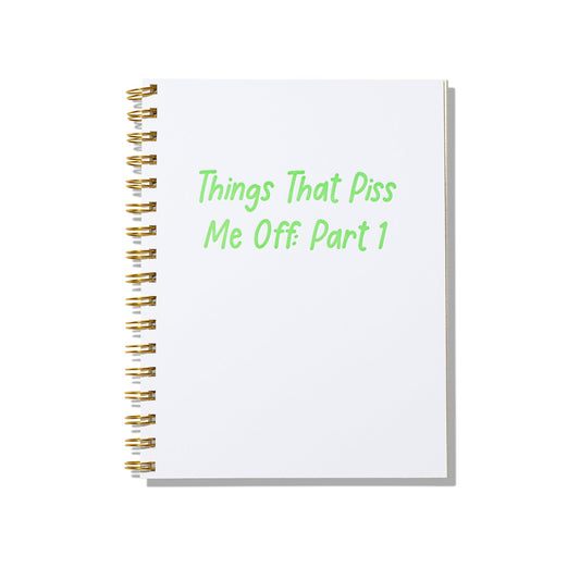 Large letterpress notebook with “Things That Piss Me Off: Part 1” in green text on white cover with gold spiral binding.
