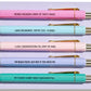 Set of five pastel pens with gold accents, each printed with funny people-pleasing quotes, on branded backing card.