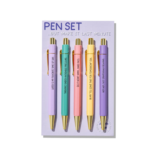 Five pastel ballpoint pens with gold accents, each printed with funny procrastination phrases, displayed on branded backing card.