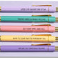 Close-up of five pastel click pens with gold details and humorous last-minute quotes, stationery gift for procrastinators.
