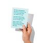 Funny new home card held in hand, humorous moving day humor visible.