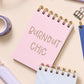 Pink letterpress mini jotter with gold text “Burnout Chic” and gold spiral binding.
