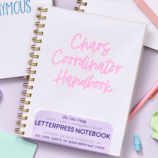 Funny letterpress notebook for multitaskers with bold pink text on white rigid cover.
