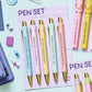 Set of pastel pens with gold accents and profanity-filled phrases, packaged in a 5-pack gift-ready set.
