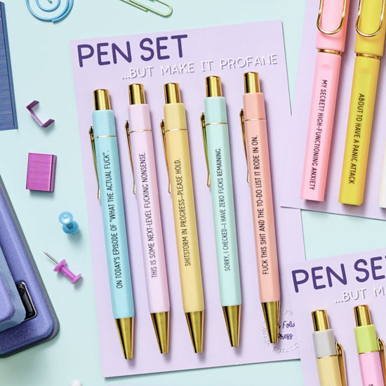 Set of pastel pens with gold accents and profanity-filled phrases, packaged in a 5-pack gift-ready set.

